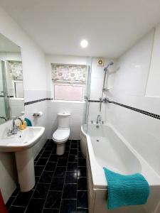 a bathroom with a sink and a tub and a toilet at In the heart of Portrush - Beautiful Views in Portrush