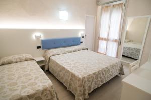 Łóżko lub łóżka w pokoju w obiekcie Hotel Rio Bellaria