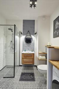 ein Bad mit einer Dusche, einem Waschbecken und einem WC in der Unterkunft Apartament Żoliborz Arkadia by Renters Prestige in Warschau