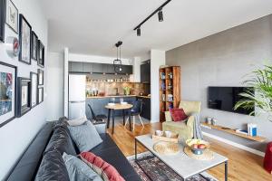 ein Wohnzimmer mit einem Sofa und einem Tisch in der Unterkunft Apartament Żoliborz Arkadia by Renters Prestige in Warschau