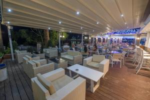 a restaurant with white couches and tables and chairs at Karousos Beach Rooms in Ayia Napa
