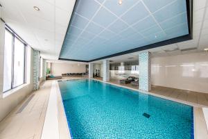 een groot zwembad met een blauw plafond bij Fletcher Hotel-Restaurant Jagershorst-Eindhoven in Leende