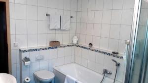 a white bathroom with a tub and a toilet at Ferienwohnungen Schlossblick in Muhr amSee +16 photos