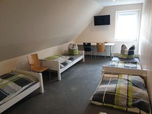 a room with two beds and a table and chairs at Pension Citytravel in Espelkamp-Mittwald