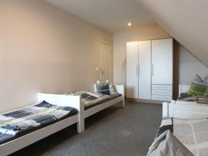 a bedroom with two beds and a cabinet in it at Pension Citytravel in Espelkamp-Mittwald