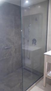 a shower with a glass door in a bathroom at Karousos Beach Rooms in Ayia Napa