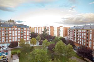 una città con edifici alti e un parco alberato di Housingleón - San Marcos con garaje a León