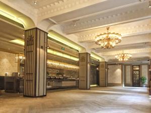 a large lobby with columns and a chandelier at Jinjiang Metropolo Hotel Classic Nanjing Road (East) Shanghai in Shanghai