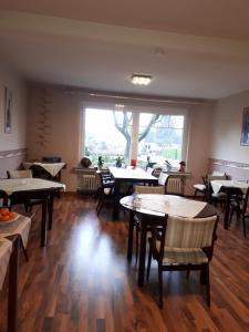 a restaurant with tables and chairs and a large window at Gästehaus Temme in Bad Rothenfelde