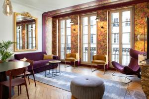 une chambre avec des chaises, des tables et des fenêtres dans l'établissement Maison Tillot, à Dijon