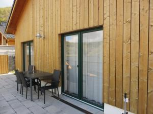 un patio con mesa y sillas junto a un edificio en Eifel & See - Ferienhäuser am Waldsee Rieden/Eifel, en Rieden