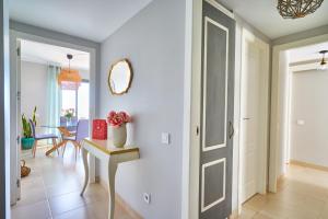 a hallway with a door and a table with a vase of flowers at Sea View Penthouse, Pool, Privacy, Benalmadena in Benalmádena