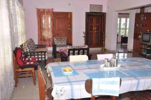 a living room with a table and chairs at Meghagiri homestay in Chārmādi