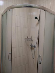 y baño con ducha y puerta de cristal. en Budget Hotel Ekotel, en Leópolis