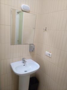 La salle de bains est pourvue d'un lavabo et d'un miroir. dans l'établissement Budget Hotel Ekotel, à Lviv
