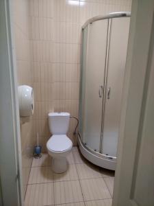La salle de bains est pourvue d'une douche et de toilettes blanches. dans l'établissement Budget Hotel Ekotel, à Lviv