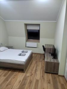 a bedroom with a bed and a desk and a window at Budget Hotel Ekotel in Lviv