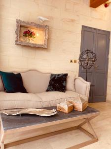 a couch and a table in a room at Lulu Boutique Hotel in Żebbuġ