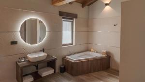 Un baño con bañera, lavabo y espejo. en Hotel Rural Cantexos, en Luarca