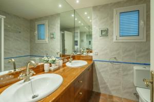 baño con 2 lavabos y espejo grande en CA-4 CALELLA DE PALAFRUGELL 4 PAX, en Calella de Palafrugell
