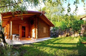 a log cabin with a porch in a yard at Canè in fiore in Baselga di Pinè