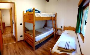 a room with two bunk beds and a hallway at Canè in fiore in Baselga di Pinè
