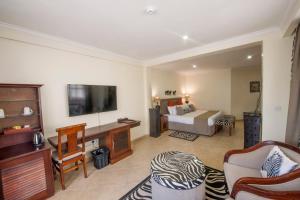 a hotel room with a bed and a television at African Tulip in Arusha