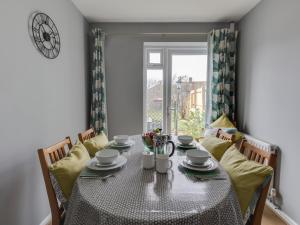a dining room with a table and chairs and a window at The Lookout -The House With A View in Weymouth