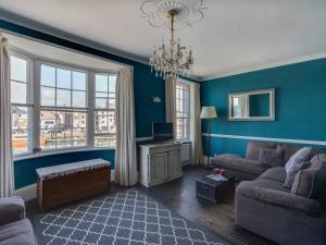 sala de estar con paredes azules y sofá en Sailor's Watch, en Weymouth