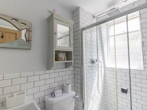 a white bathroom with a toilet and a window at Sailor's Watch in Weymouth +26 photos