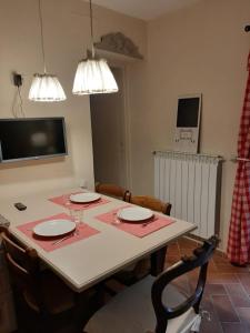 een eetkamer met een tafel met stoelen en een tv bij Agula Relais appartamento in Pugnano