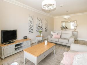 a living room with a couch and a tv at Harbour Watch 2 in Weymouth