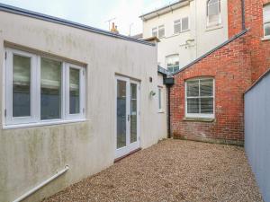 an alley between two brick buildings with a door at Harbour Watch 2 in Weymouth
