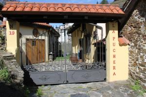 an entrance to a building with a gate and a sign at La Puchera in Cangas del Narcea