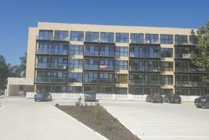 a large building with cars parked in a parking lot at Garsoniera Saturn in Saturn