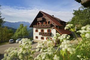 un bâtiment avec des voitures garées dans un parking dans l'établissement Farm Stay "Alpine Dreams", à Solčava