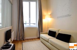 - un salon avec un canapé et une fenêtre dans l'établissement 102467 - Appartement 1 Chambre Montorgueil, à Paris