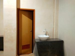 a bathroom with a sink on a counter next to a door at Bunar Tunggal Villa n Resto in Tanjung Lesung