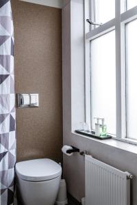 a bathroom with a toilet and a window at Hotel Leifur Eiriksson in Reykjavík