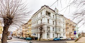 a large white building with cars parked on a street at Teplice Apartments U Schodů in Teplice