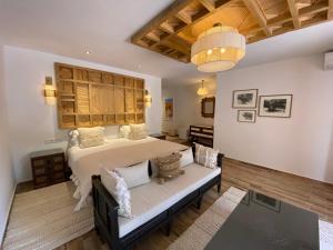 ein Schlafzimmer mit einem Bett und einem Sofa in einem Zimmer in der Unterkunft Domaine de la Roseraie Resort in Ouirgane