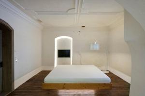 a white room with a bed and a tv at Turmhotel in Enns