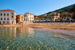 una persona in piedi sull'acqua su una spiaggia con ombrelloni di Hotel La Pergola a Santa Maria di Castellabate Altre 17 foto