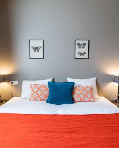 a bedroom with a bed with orange and blue pillows at Hotel Leifur Eiriksson in Reykjavík