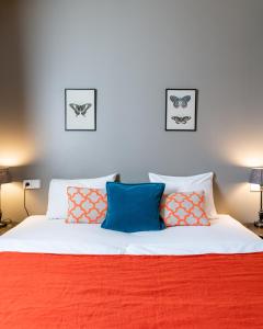 - une chambre dotée d'un lit avec des oreillers orange et bleu dans l'établissement Hotel Leifur Eiriksson, à Reykjavik