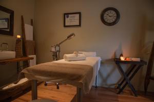 a room with a bed with a clock on the wall at VillaChad Guesthouse in Kleinmond