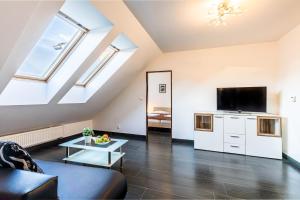 a living room with a couch and a flat screen tv at Teplice Apartments Dlouhá in Teplice