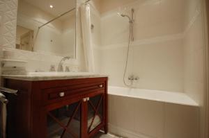 a bathroom with a tub and a sink and a shower at 103321 - Appartement 4 personnes Marais - Bastille in Paris