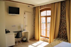 ein Hotelzimmer mit einem Bett und einem Fenster in der Unterkunft Hostellerie De Biek in Moorsel