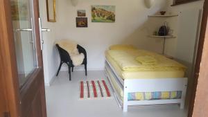 a small bedroom with a bed and a chair at Rustico in Miglieglia